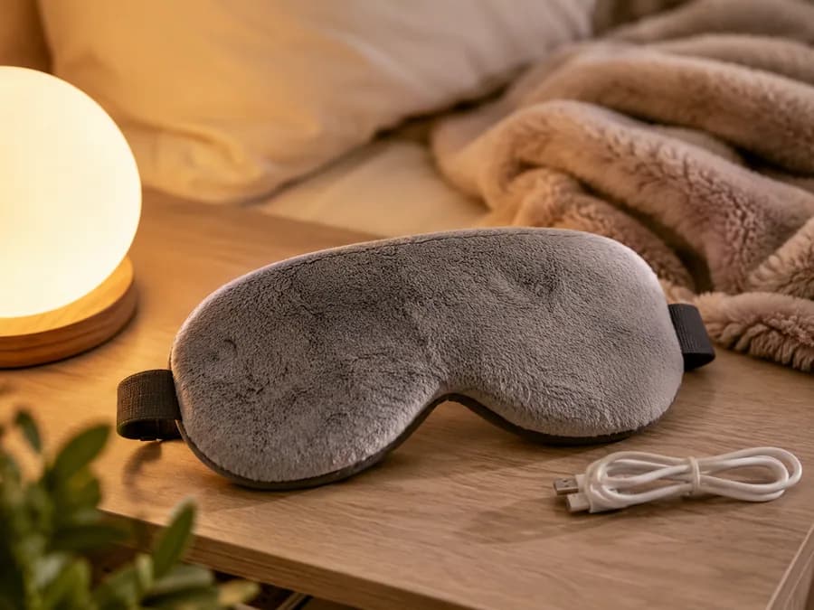 Heated Eye Mask Product Image Heated eye mask on bedside table with warm sleep routine setting
